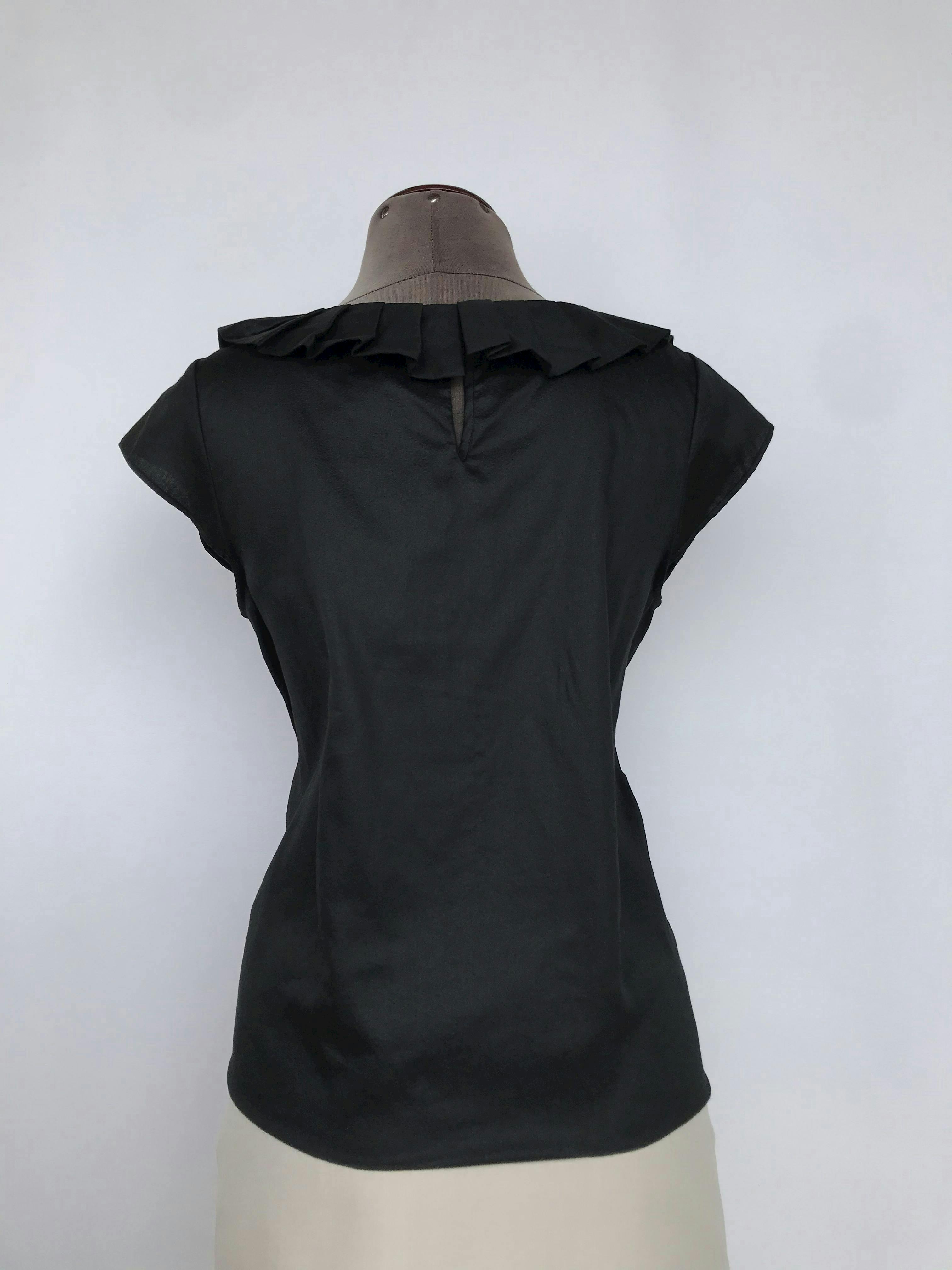 Blusa Club Monaco 100% algodón negro, cuello plisado y botón posterior. Precio original S/300
Talla M