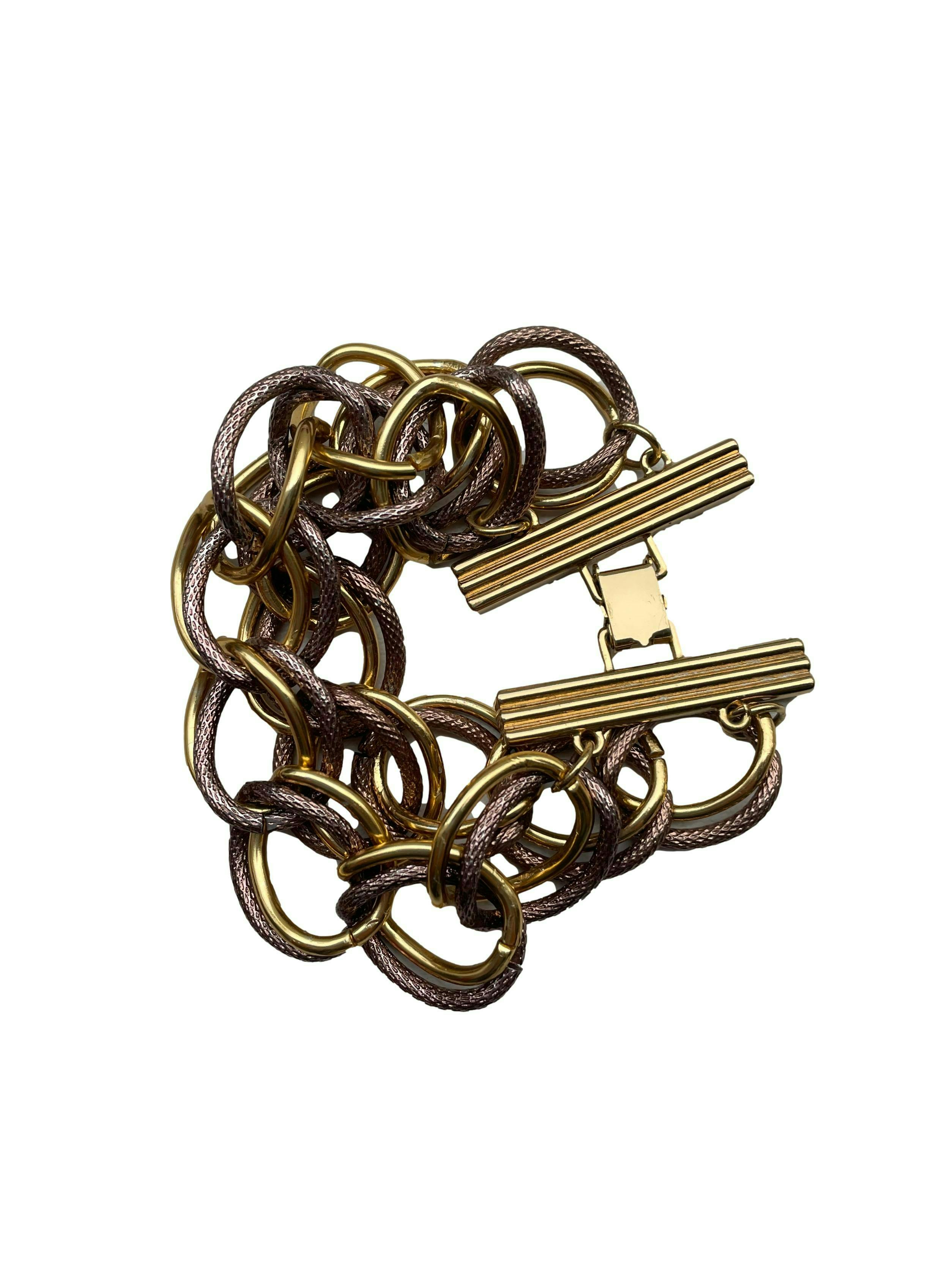 Pulsera de metal con doble cadena en dorado y cobrizo, cierre tipo pato. Con bolsita protectora. Largo 20cm, Ancho 5cm.