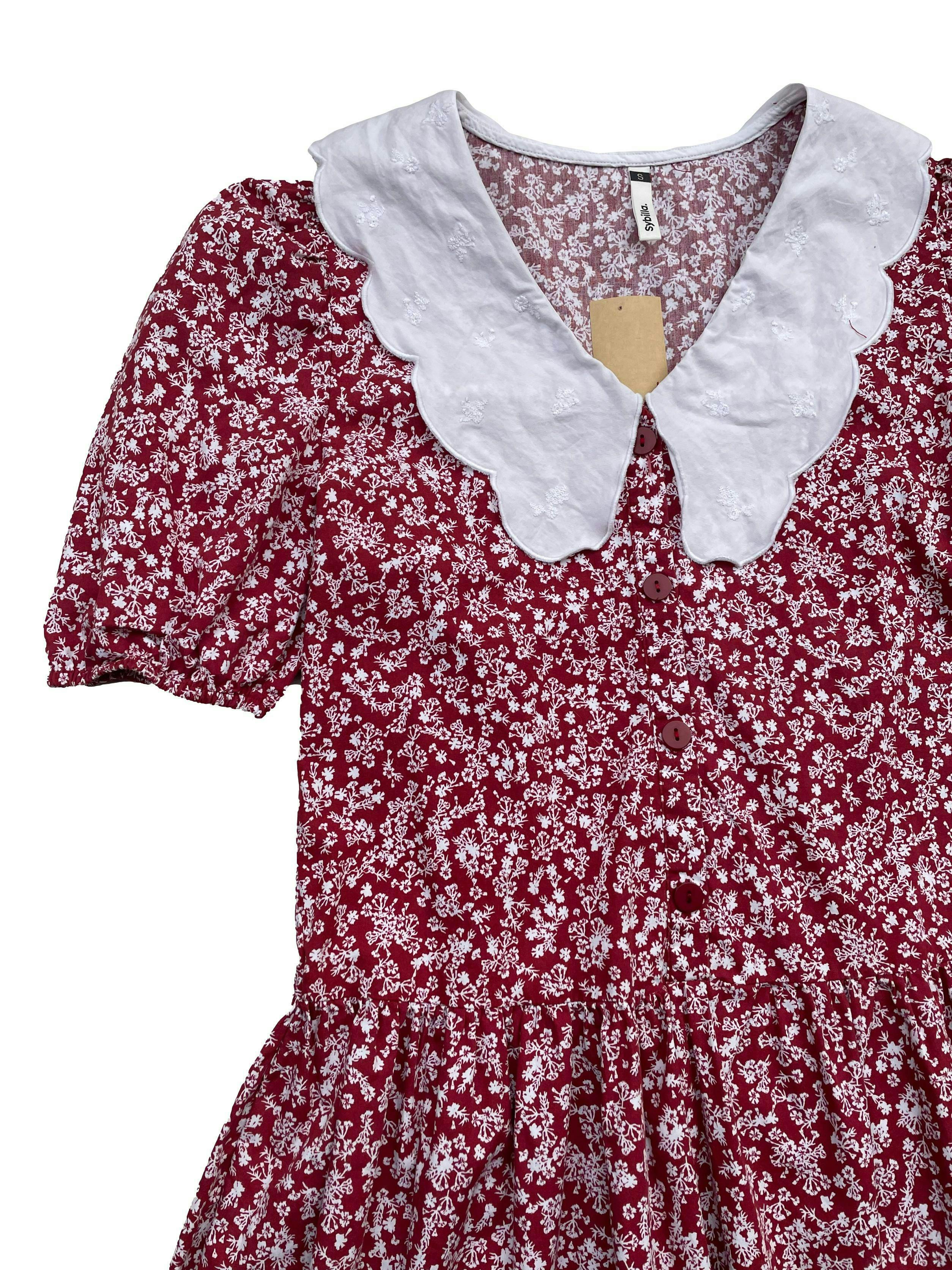 Vestido Sybilla rojo con florcitas, tela tipo camisa, maxicuello y botones delanteros. Busto: 90cm, largo: 76cm.
