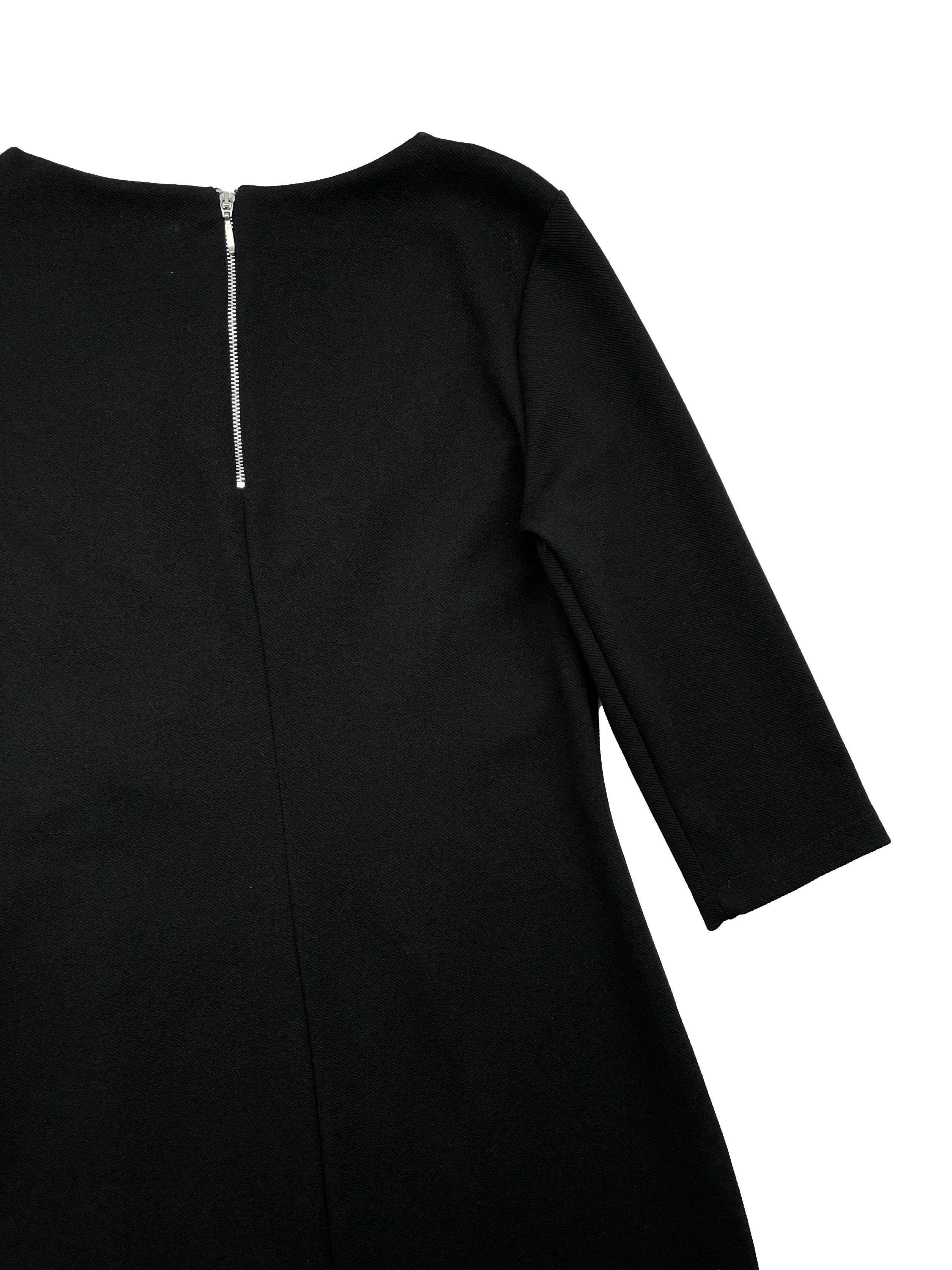 Vestido negro de tela stretch, cruce frontal con botones plateados, mangas 3/4, cierre metálico posterior. Busto 88cm sin estirar, Largo 80cm.