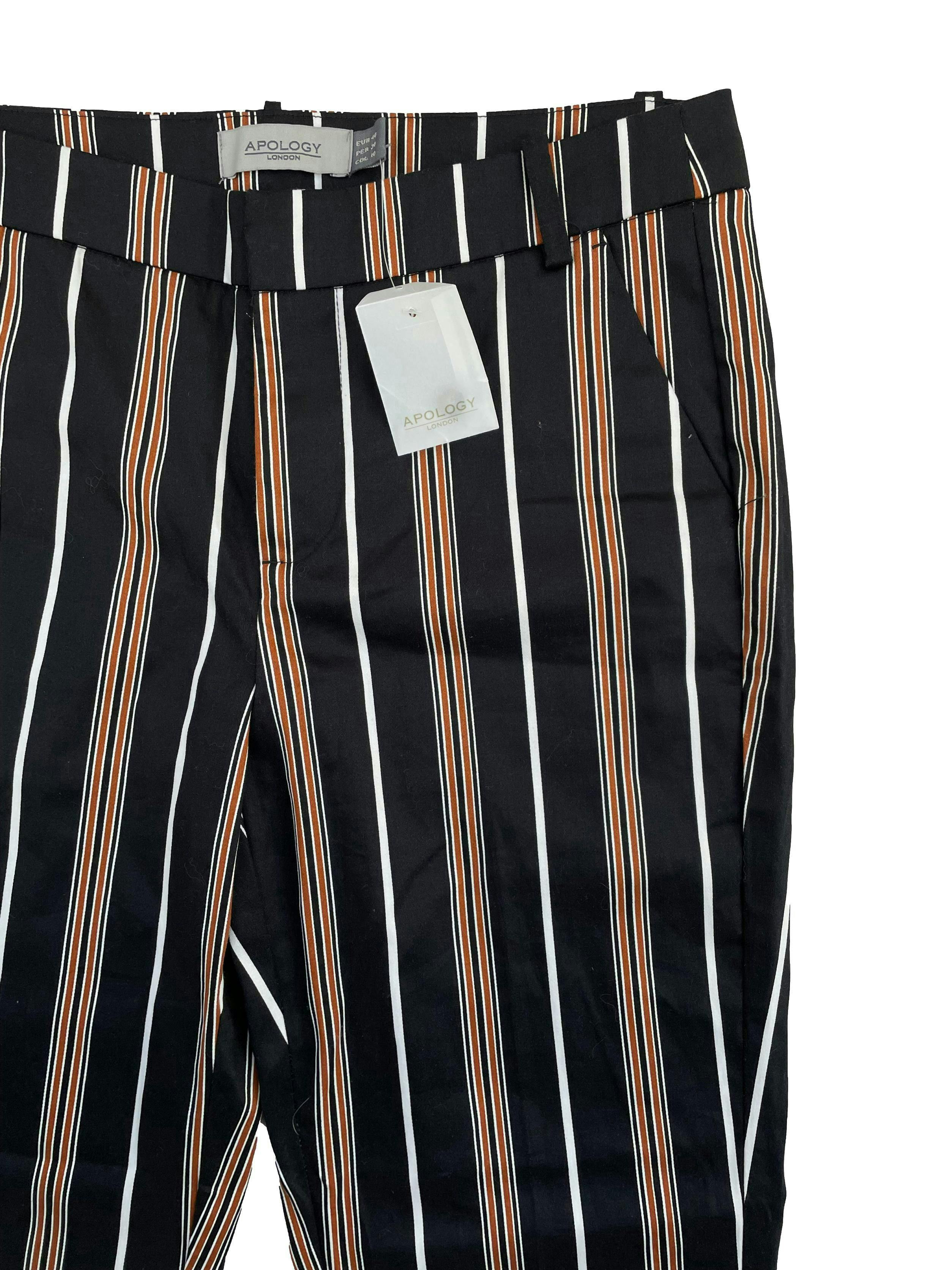 Pantalón Apology negro con rayas blancas y marrones verticales, bolsillos delanteros, corte slim. Cintura: 80cm, Largo: 98cm, Tiro: 26cm. Nuevo con etiqueta.
