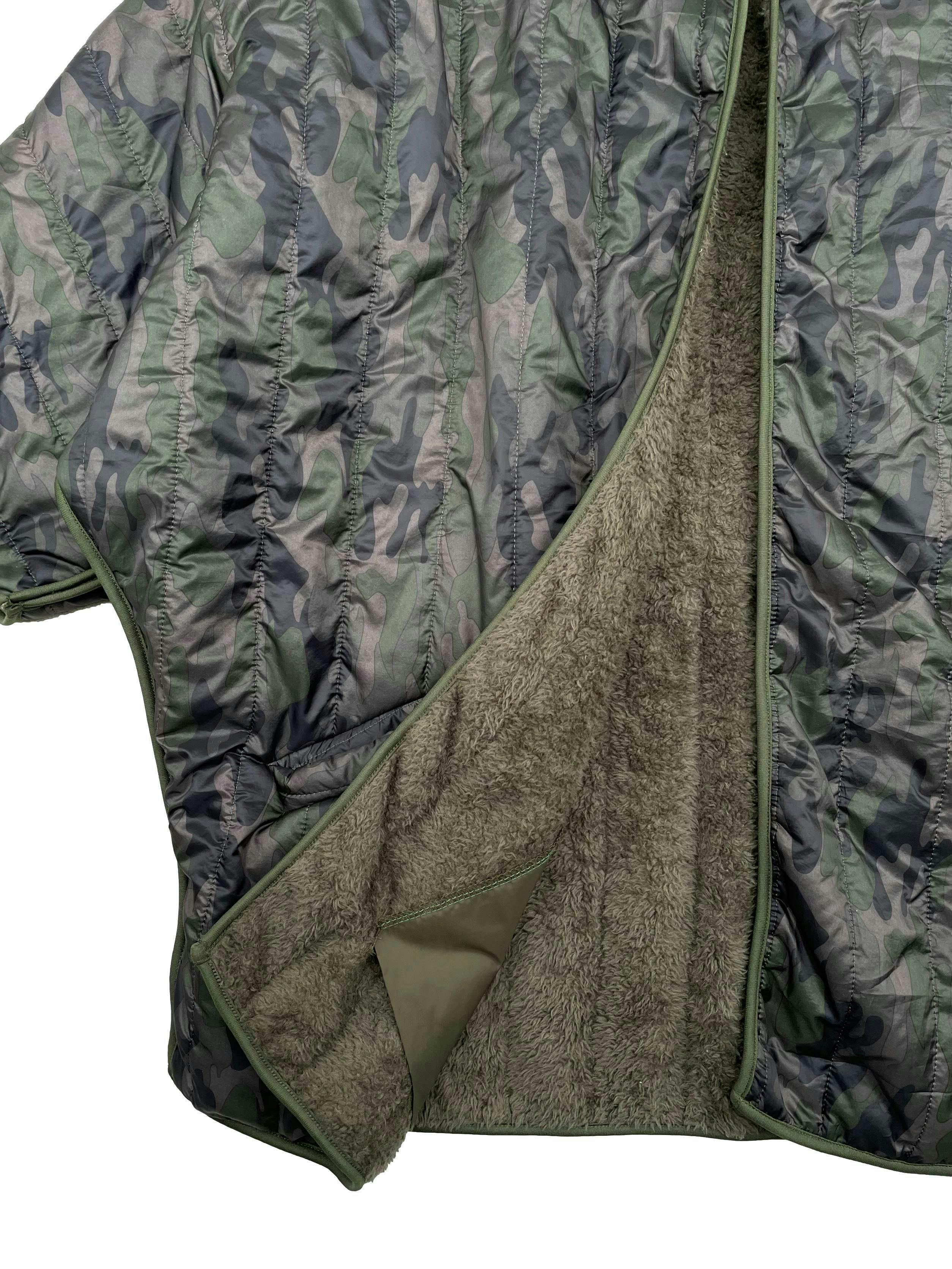 Casaca estilo impermeable estampado militar con forro de peluche, corte oversized, cuello alto y bolsillos laterales. Ancho 120cm Largo 75cm