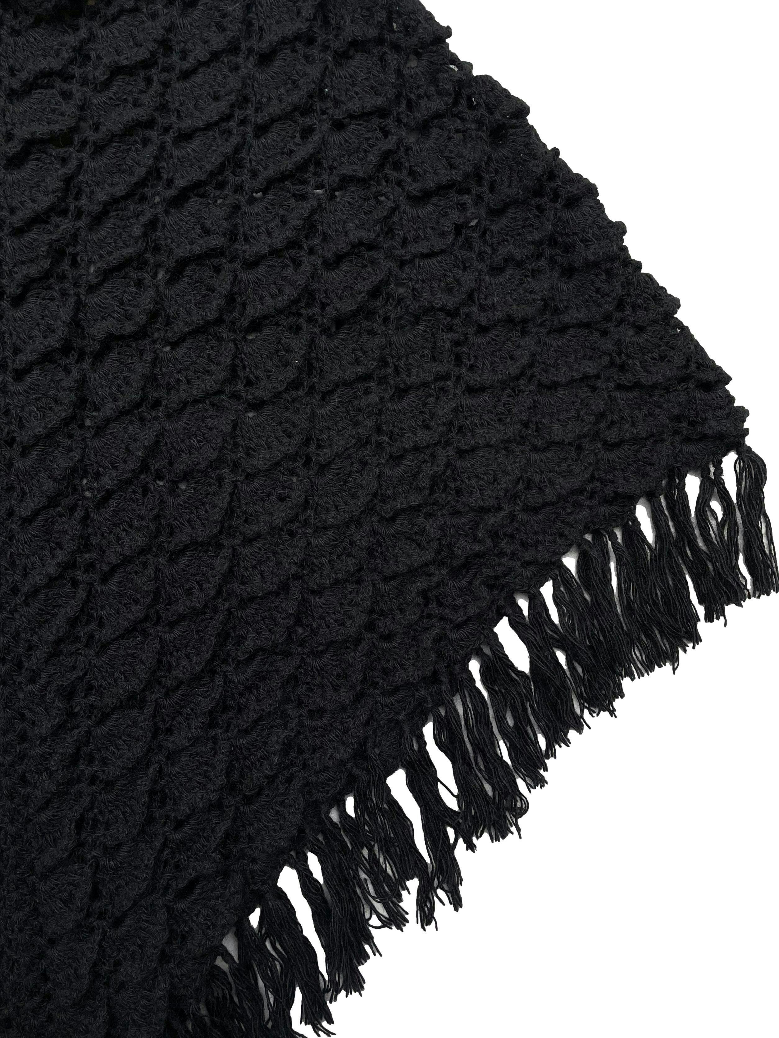 Poncho negro del Cite textil, tejido a mano en fibra de camélido, con cuello camisero y borlas. Hombros 45cm,Largo 75cm.