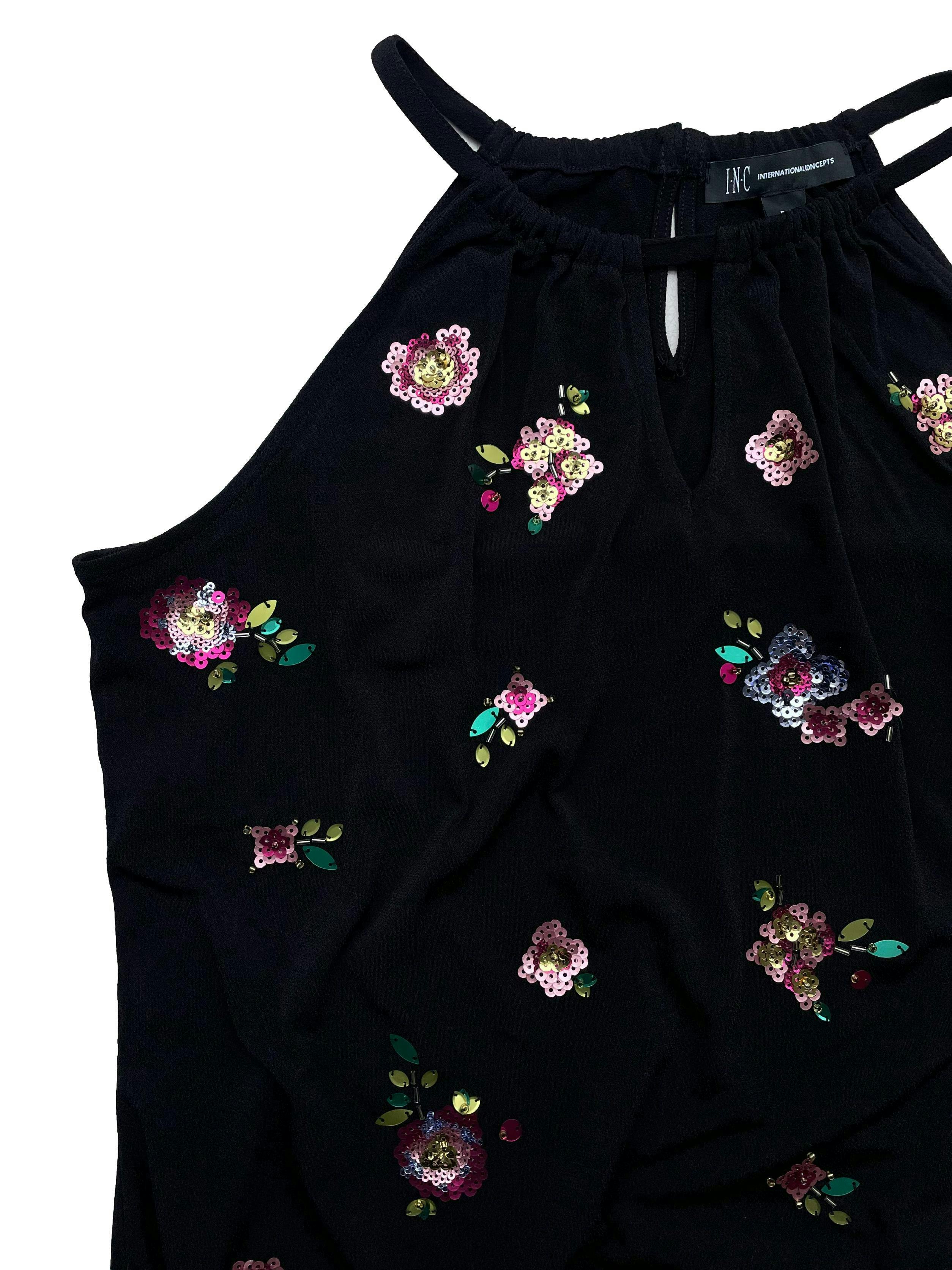 Blusa Iternational Concepts color negro, pequeña abertura en la parte delantera, manga cero, con detalle de flores en lentejuelas en la parte delantera y elástico en la parte inferior. Busto: 95cm, Largo:51cm