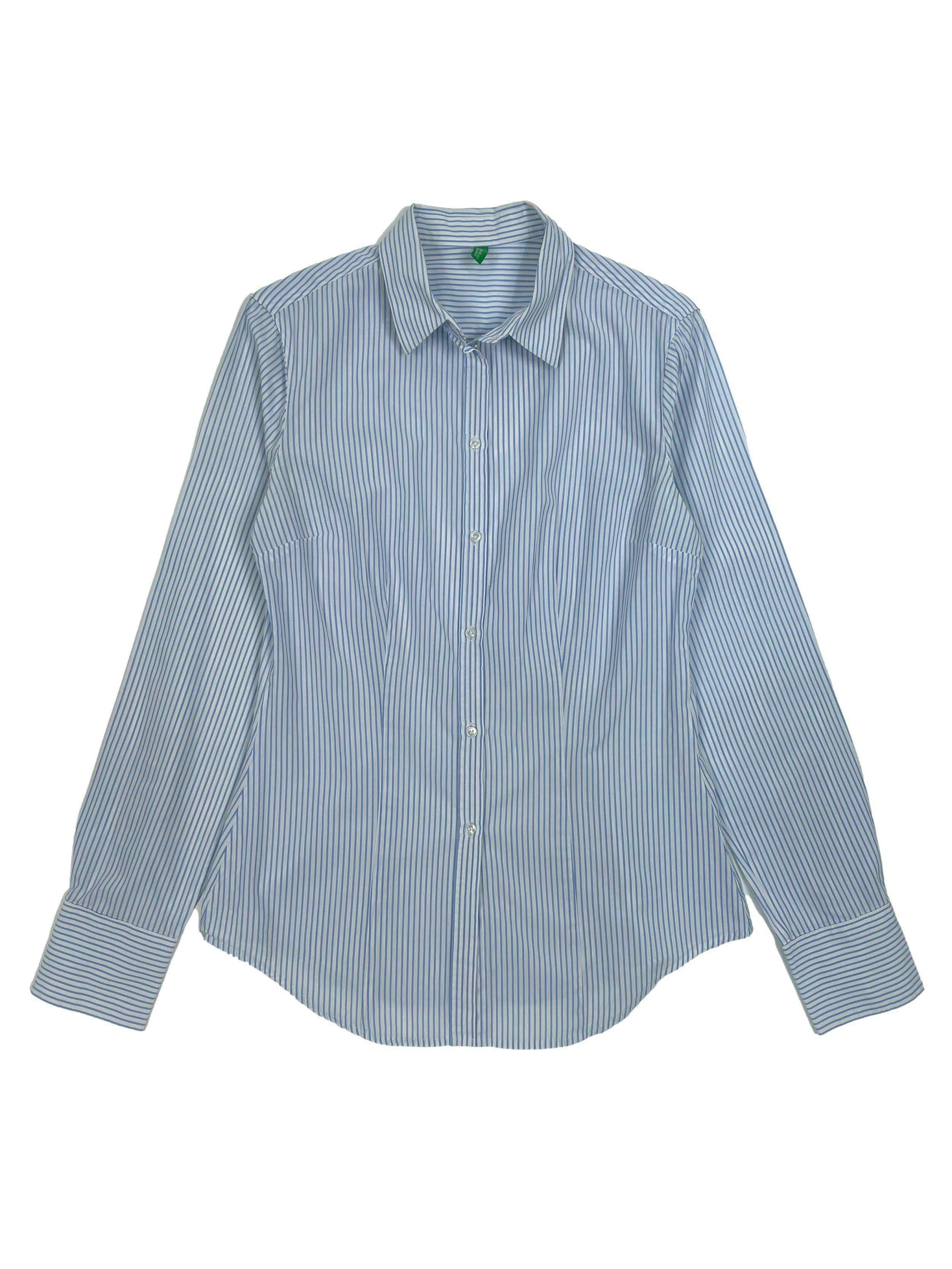  Blusa Benetton a rayas en blanco y celeste,  cuello camisero, pinzas frontales y posteriores, mangas largas y botón de repuesto.Busto 90cm, Largo 55cm.