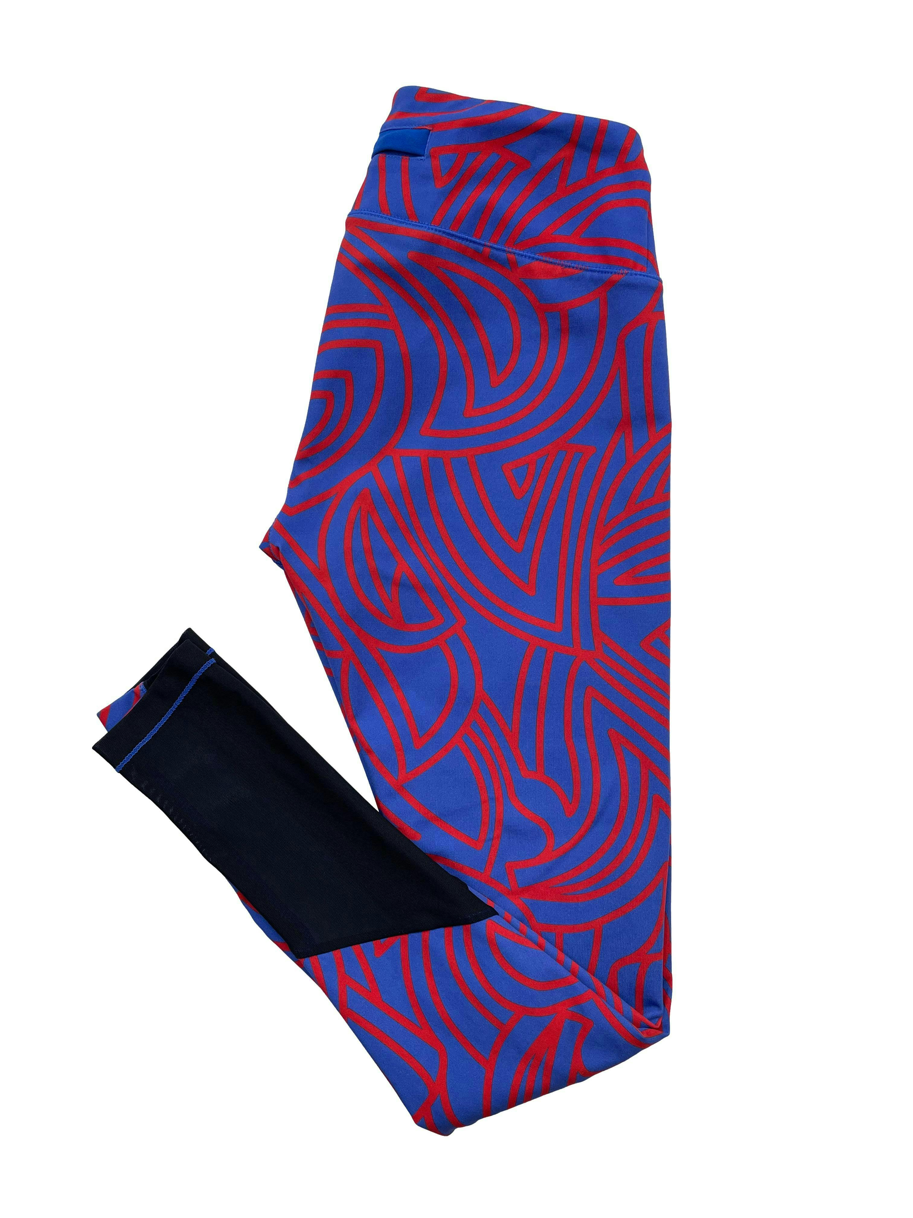 Leggings 2XIST azul con estampado lineal rojo, tiene un bolsillo posterior y mesh negro en pantorillas. Cintura 66cm sin estirar, Tiro 24cm, Largo 88cm.