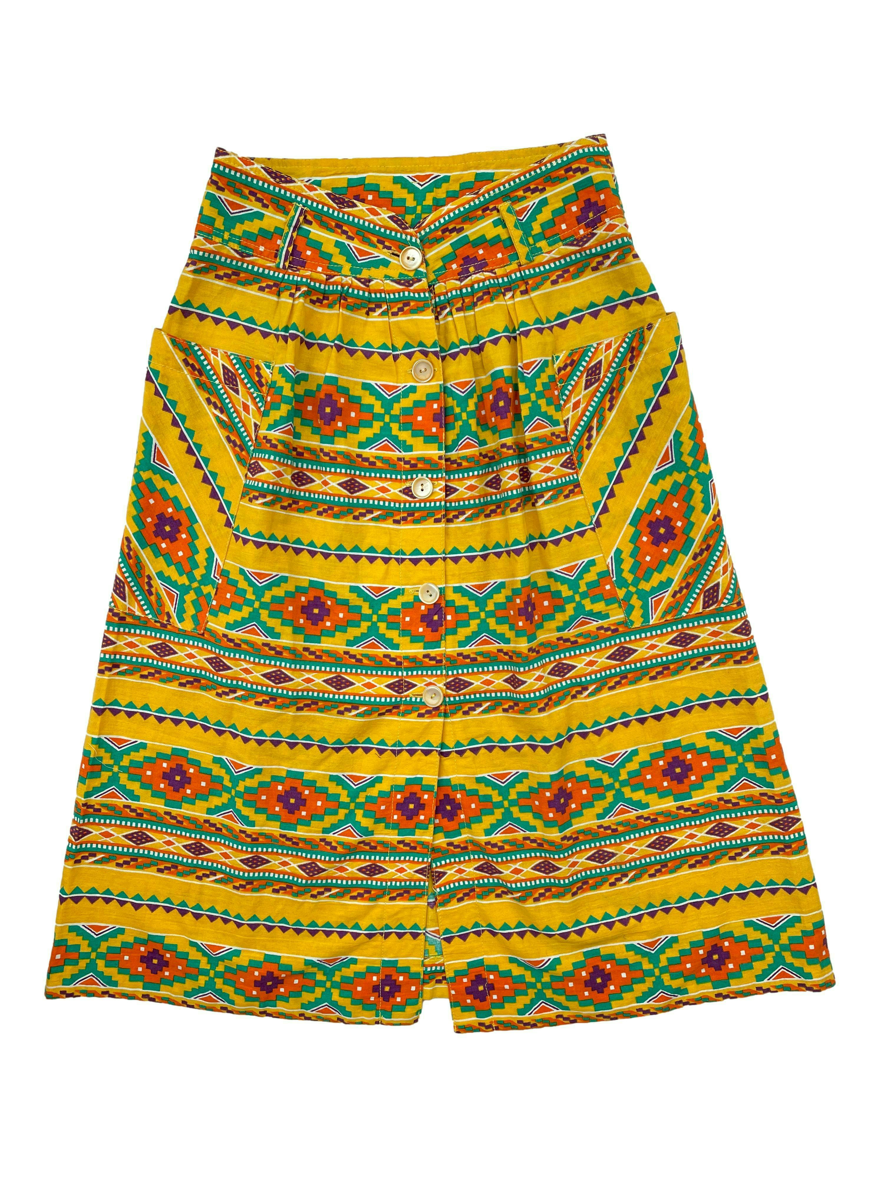Falda midi vintage amarilla con estampado tribal, bolsillos laterales y botones frontales. Cintura 64cm, Largo 70cm.