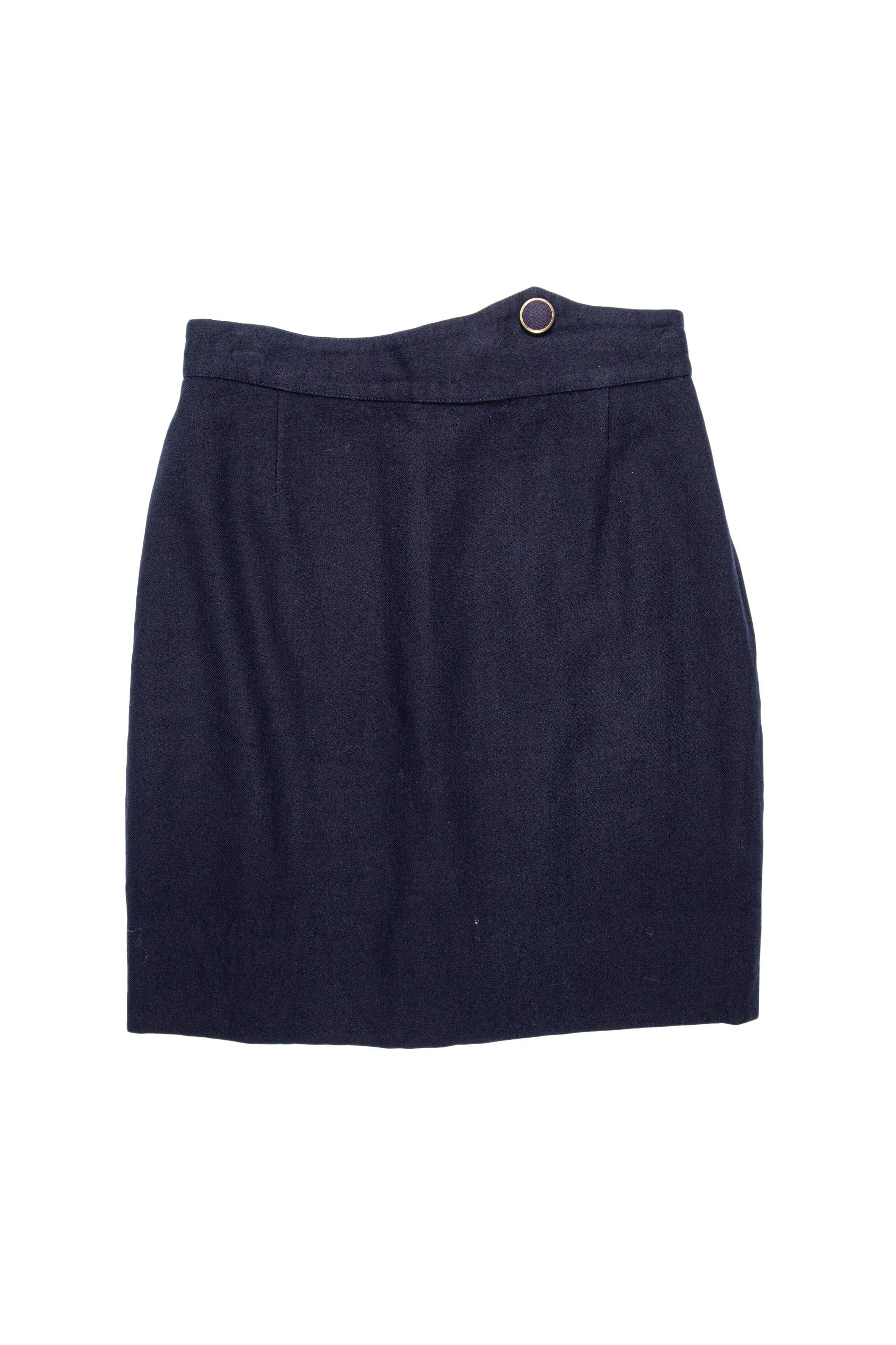 Falda de paño azul con botón forrado en la pretina, forrada y con cierre posterior. Cintura 70 cm, largo 50 cm
