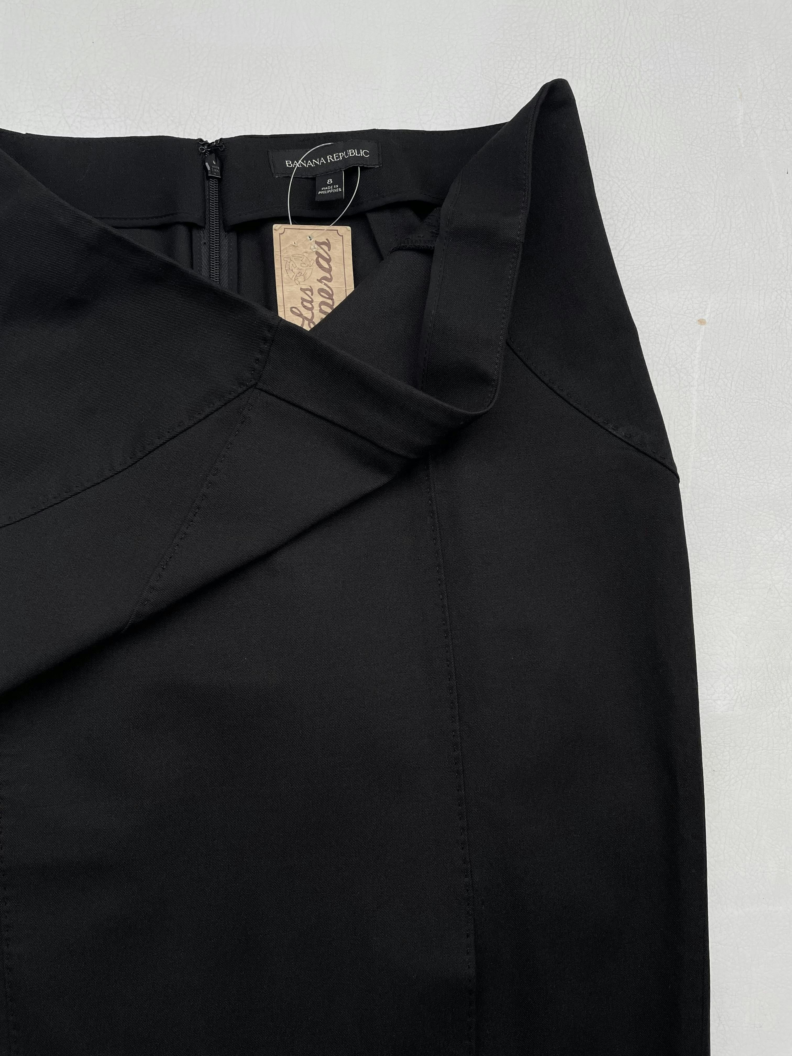 Falda formal Banana Republic negra mezcla de algodón ligeramente stretch, costuras y pespuntes al tono, abertura delantera en la basta y cierre posterior. Cintura 80cm Largo 60cm