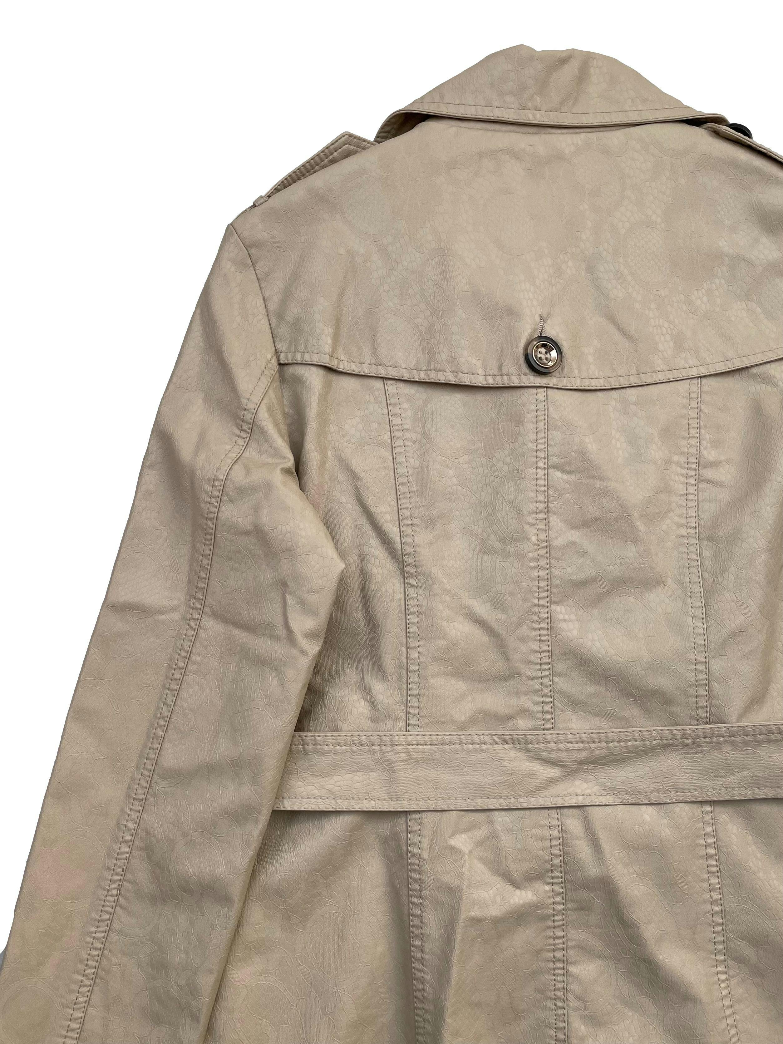 Trench Coat Moda&Cia de cuerina beige texturizada, forrada, dos bolsillos, cinturón y botón de repuesto. Busto 104cm Largo 66cm. Precio original S/450