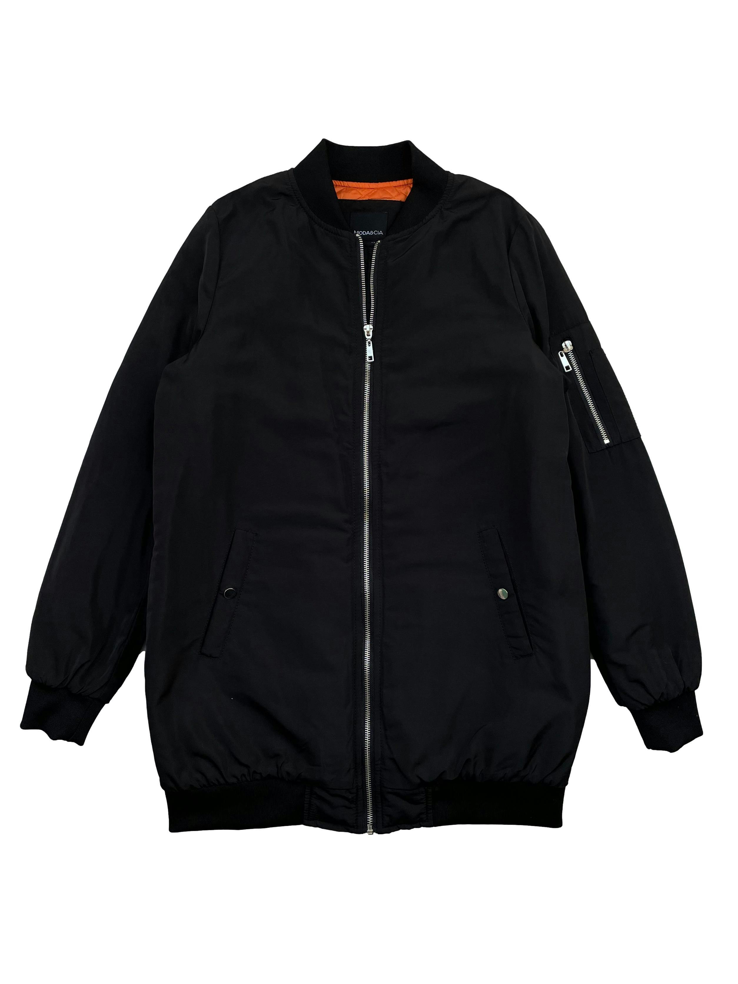 Bomber jacket Moda&Cia negra con forro naranja, ligeramente acolchada, cierre frontal , dos bolsillos delanteros y un bolsillo con cierre en el brazo. Busto 102cm , Largo 75cm. Precio original S/ 399