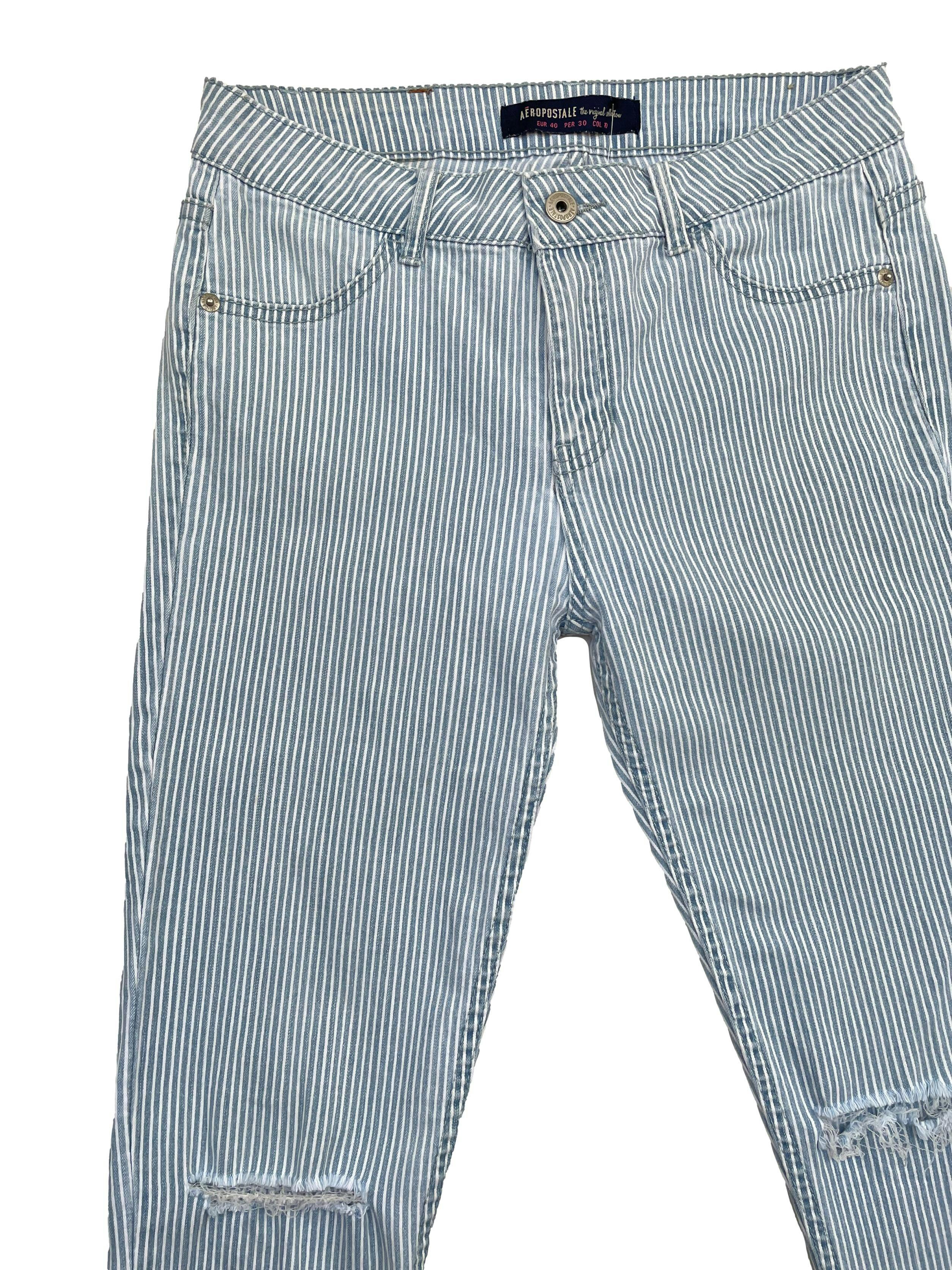 Skinny Jeans Aeropostale a rayas blancas y celestes, rasgado en las rodillas con bolsillos traseros. Cintura: 75cm, Largo: 92cm, Tiro: 24cm. Talla: 30
