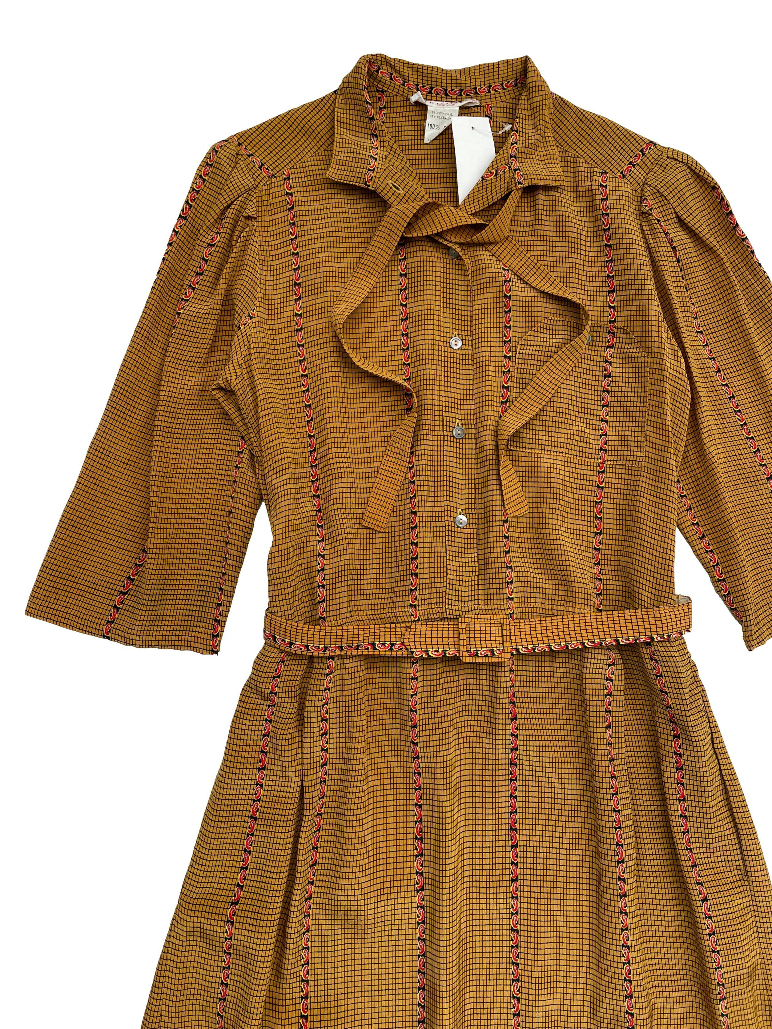 Vestido vintage 100% seda color mostaza con estampado paisley.Cuello nerú con lazo, hombros recogidos , bolsillo superior y cinturón. Largo 107cm.
