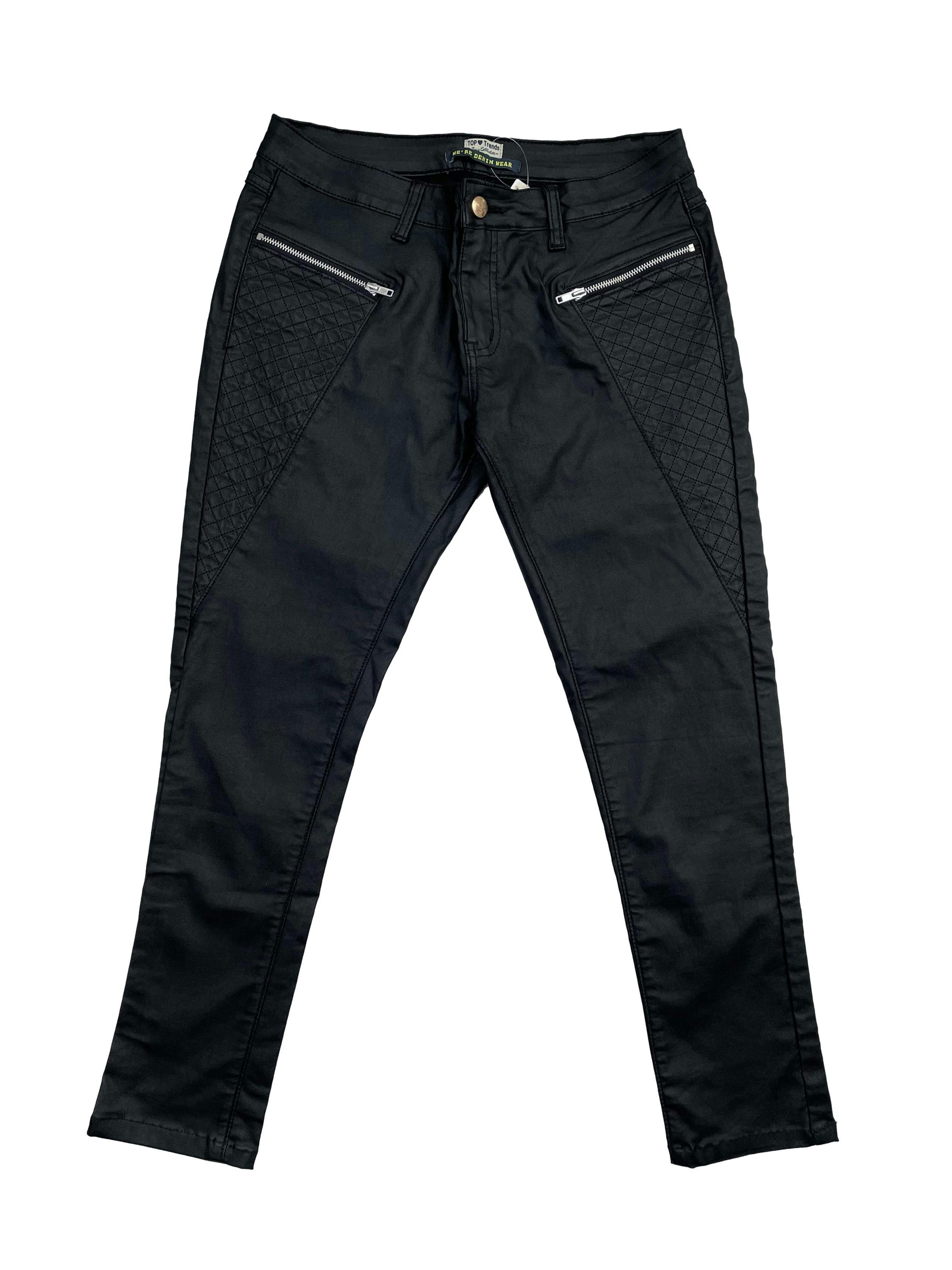 Pantalón negro pitillo, tela stretch efecto encerado, con cierres y falsos bolsillos. Tiro 22cm, Cintura 80cm, Largo 88cm.Talla S en etiqueta.