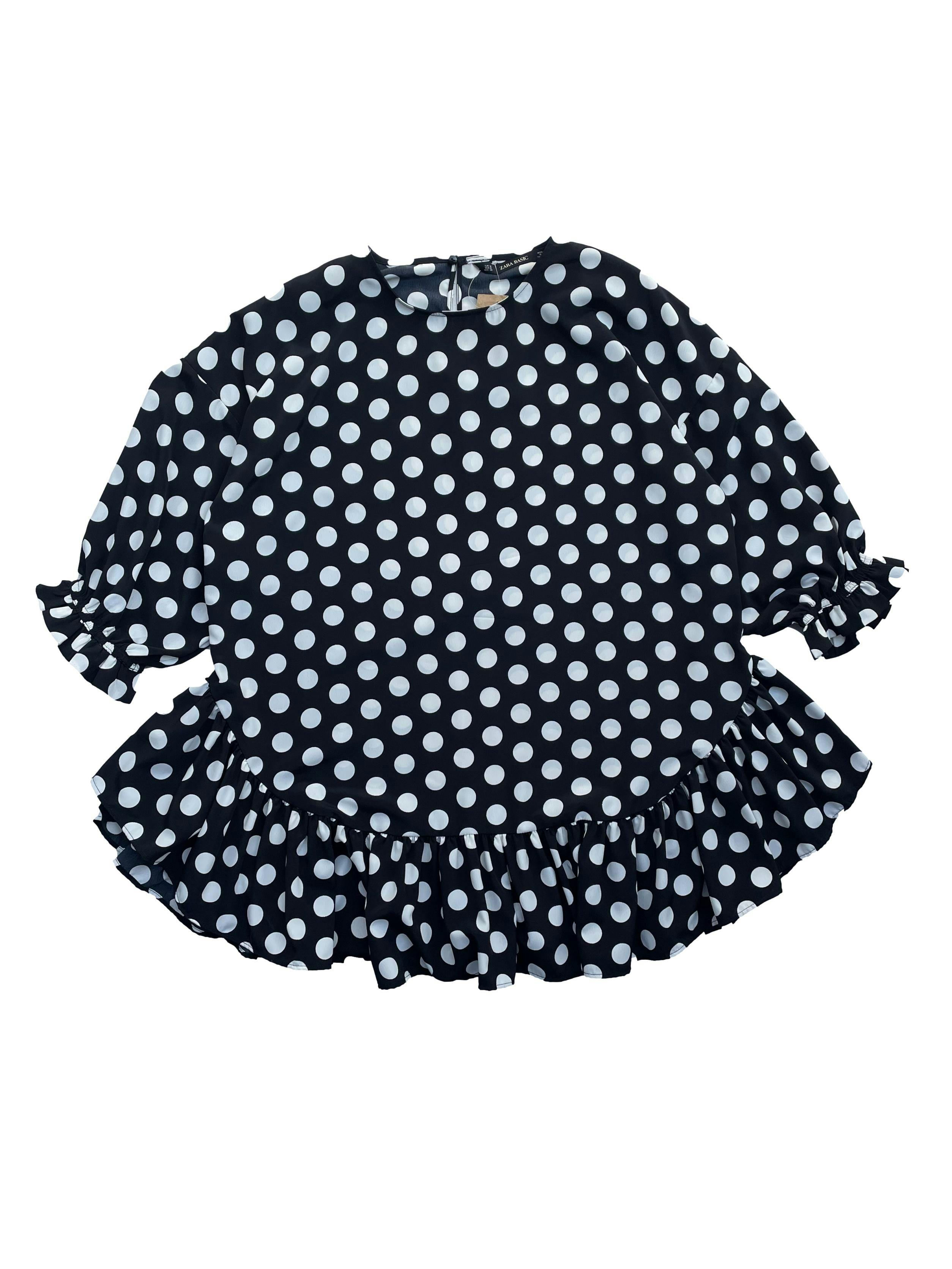 Blusón Zara negro con polka dots blancos , mangas 3/4 con elástico, volantes en basta y abertura con botón en la espalda. Busto 116cm, Largo 65cm.