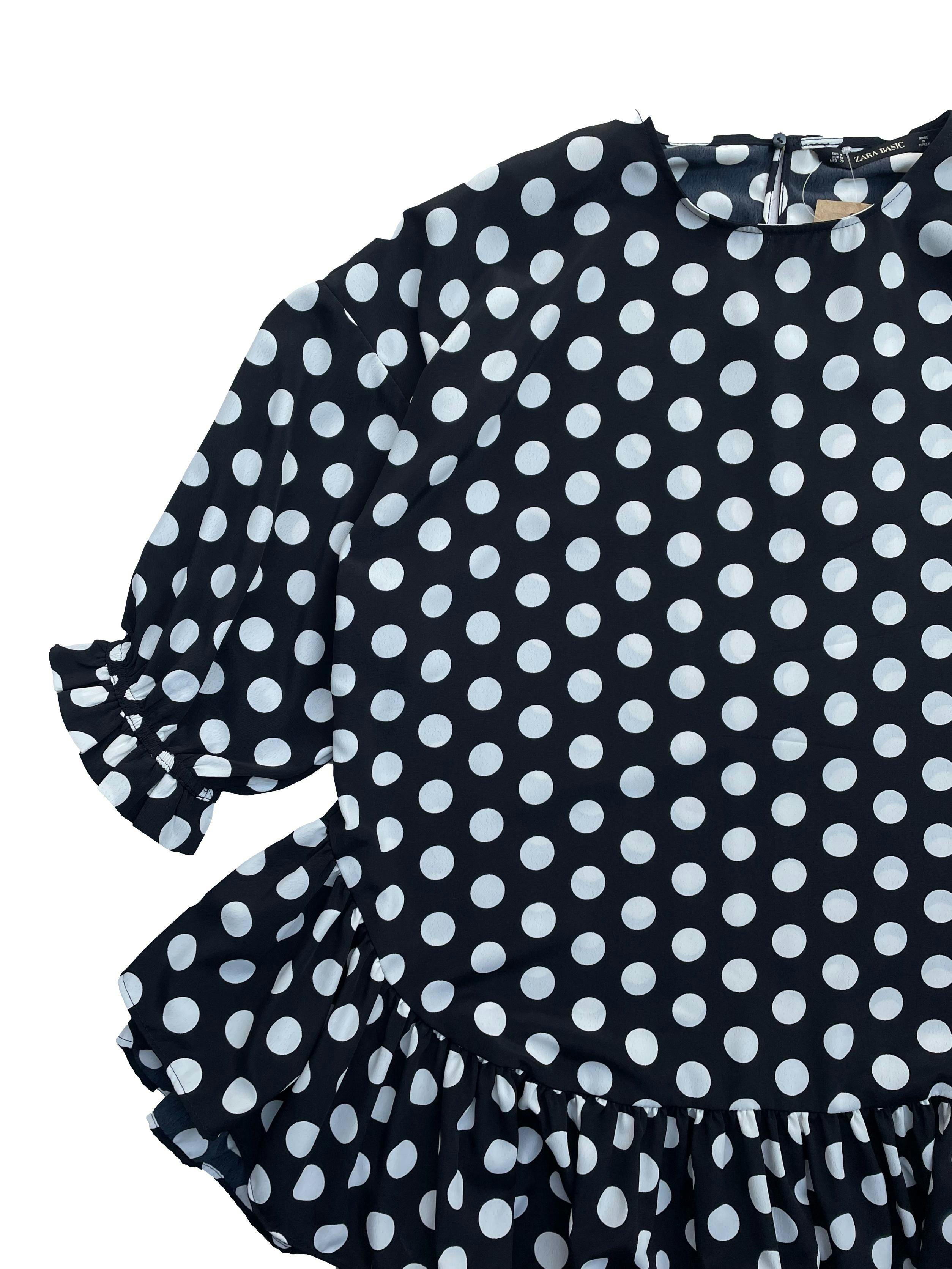 Blusón Zara negro con polka dots blancos , mangas 3/4 con elástico, volantes en basta y abertura con botón en la espalda. Busto 116cm, Largo 65cm.