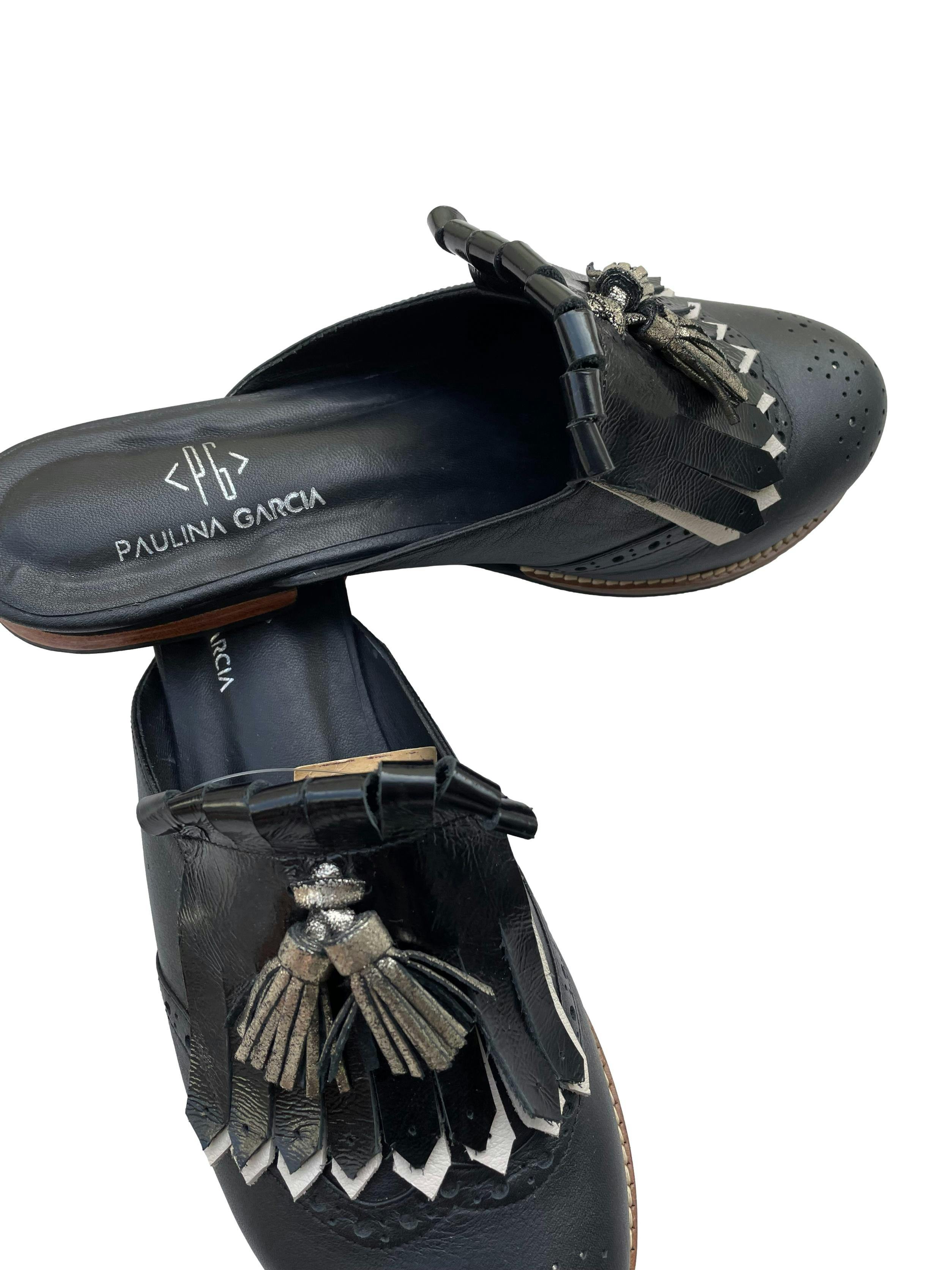 Zapatos mule Paulina Garcia, de cuero negro con flecos y borlas plateadas. Estado como nuevo. 