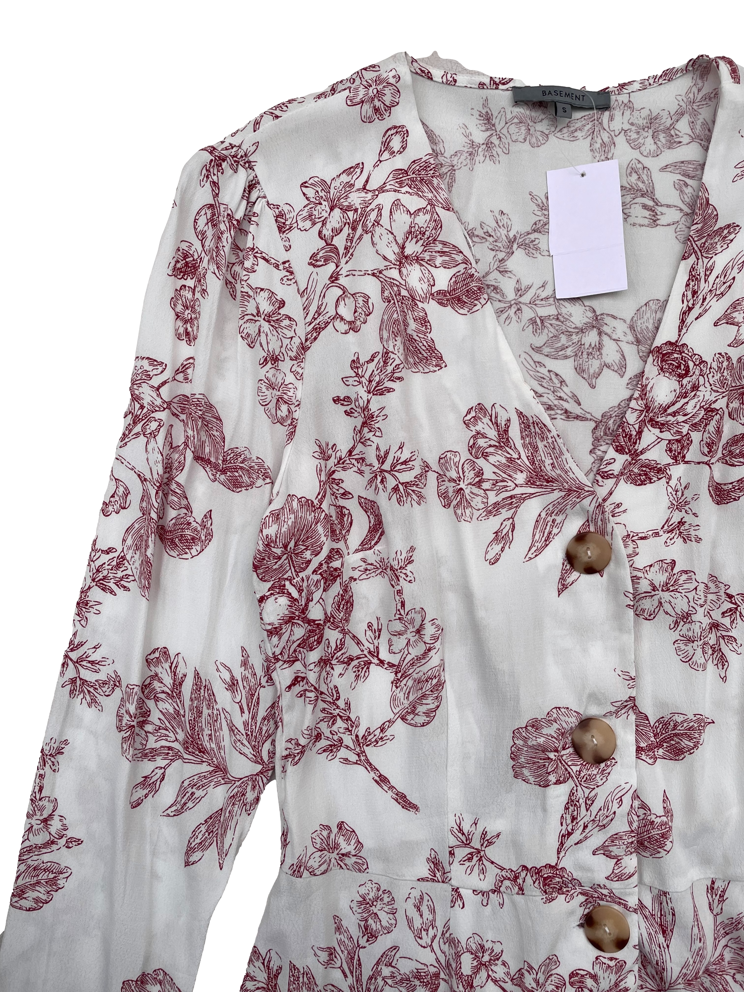 Blusa Basement de crepé blanco con estampado floral rojo, cuello en V, botones cacho, corte en cintura con elástico en espalda. Busto 96cm, Largo 58cm.