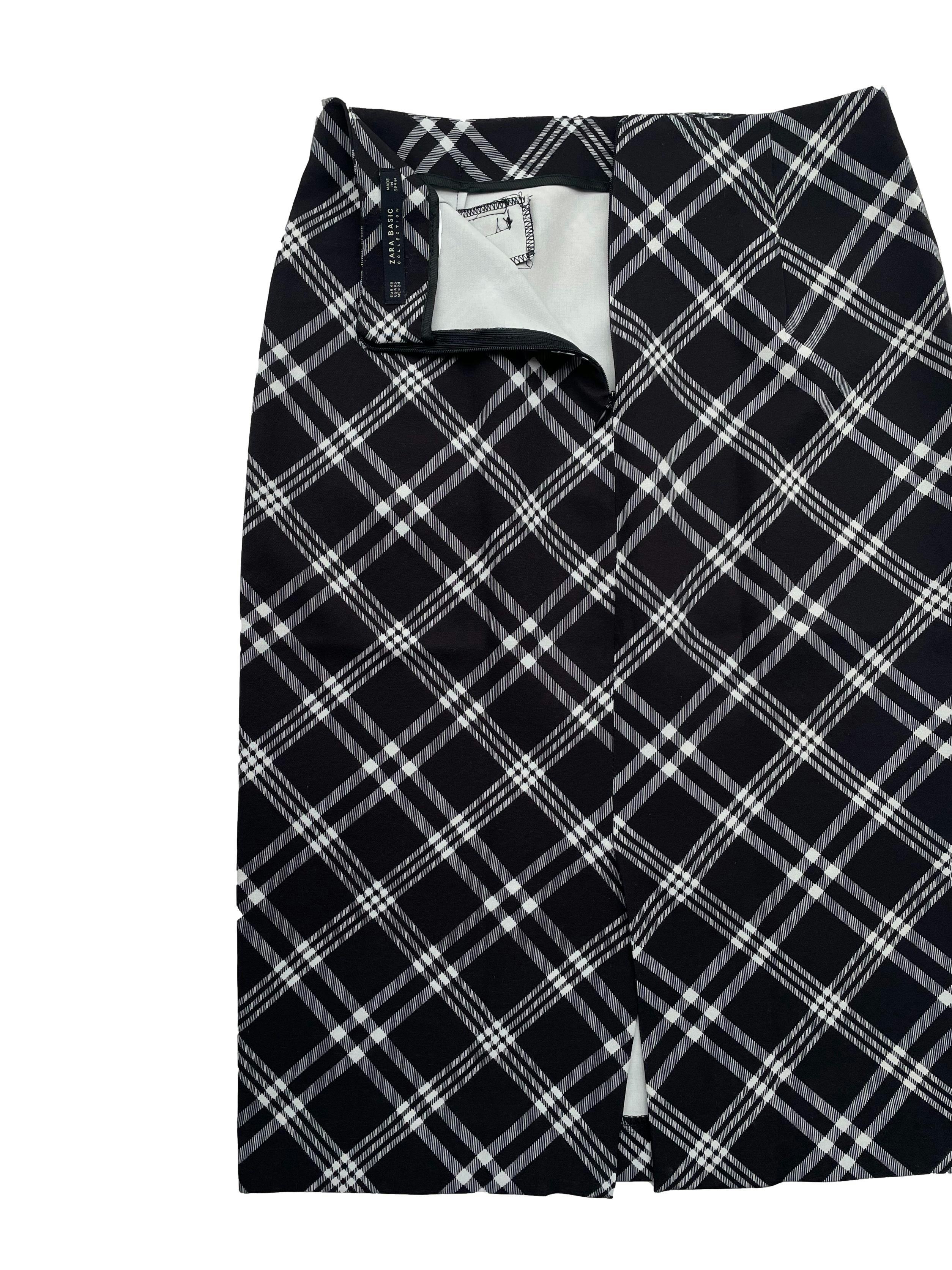 Falda lapiz Zara a cuadros en blanco y negro, tela rígida, falsos bolsillos,pinzas; cierre invisible y abertura posterior. Cintura 64cm, Largo 60cm.