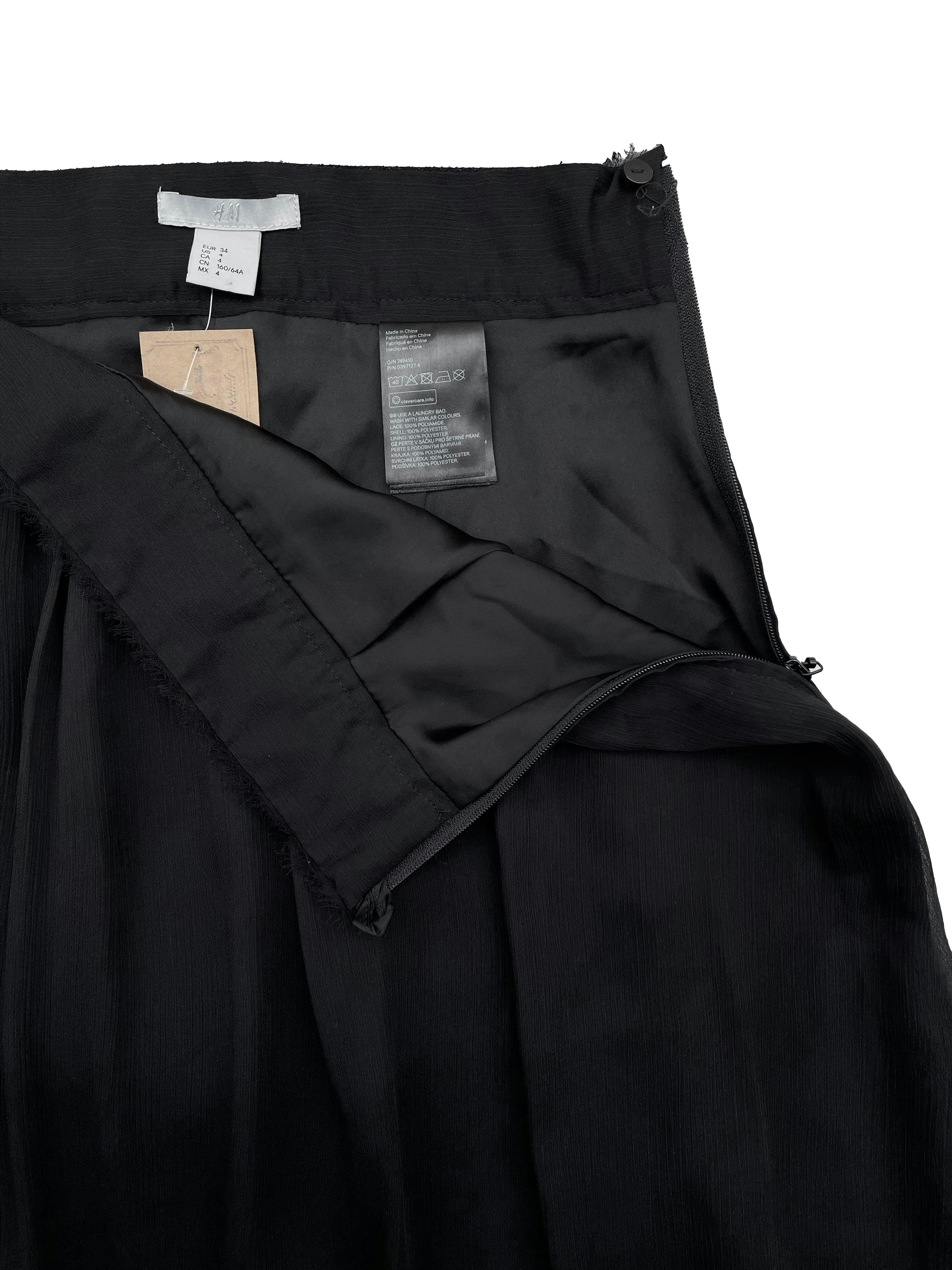 Falda H&M de gasa negra con forro, detalles desflecados y blonda en la basta, lleva cierre lateral. Cintura: 64cm, Largo: 52cm